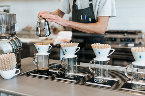 A shopkeeper serving coffee for its customers