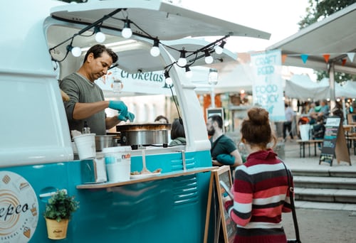 A food truck vendor is making food for its customers