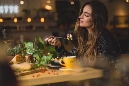 A girl enjoying food in a restaurant.