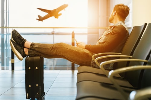 A man relaxing on his sofa enjoys sky view of flying aeroplane