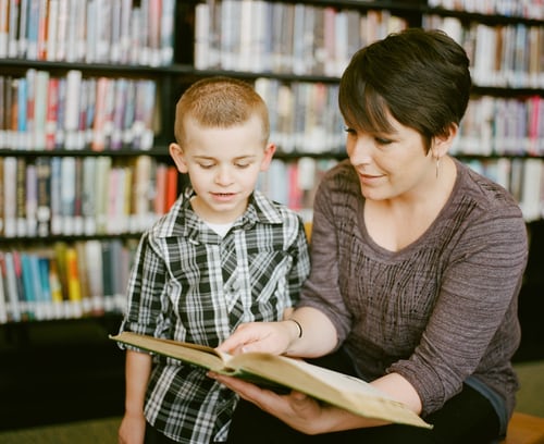 A woman is teaching a child